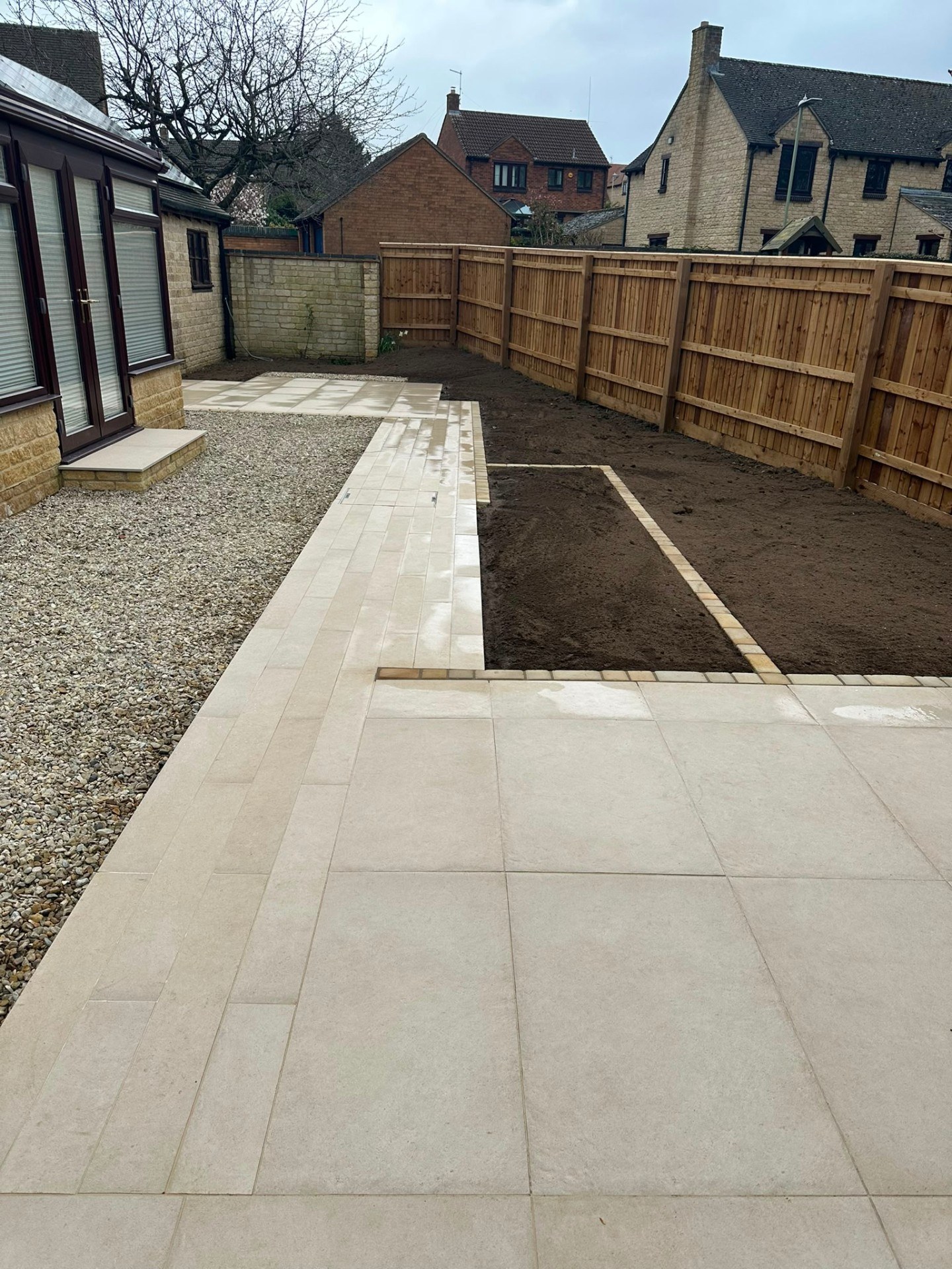 Contemporary garden landscaping with porcelain patio, timber fencing and new flower beds.