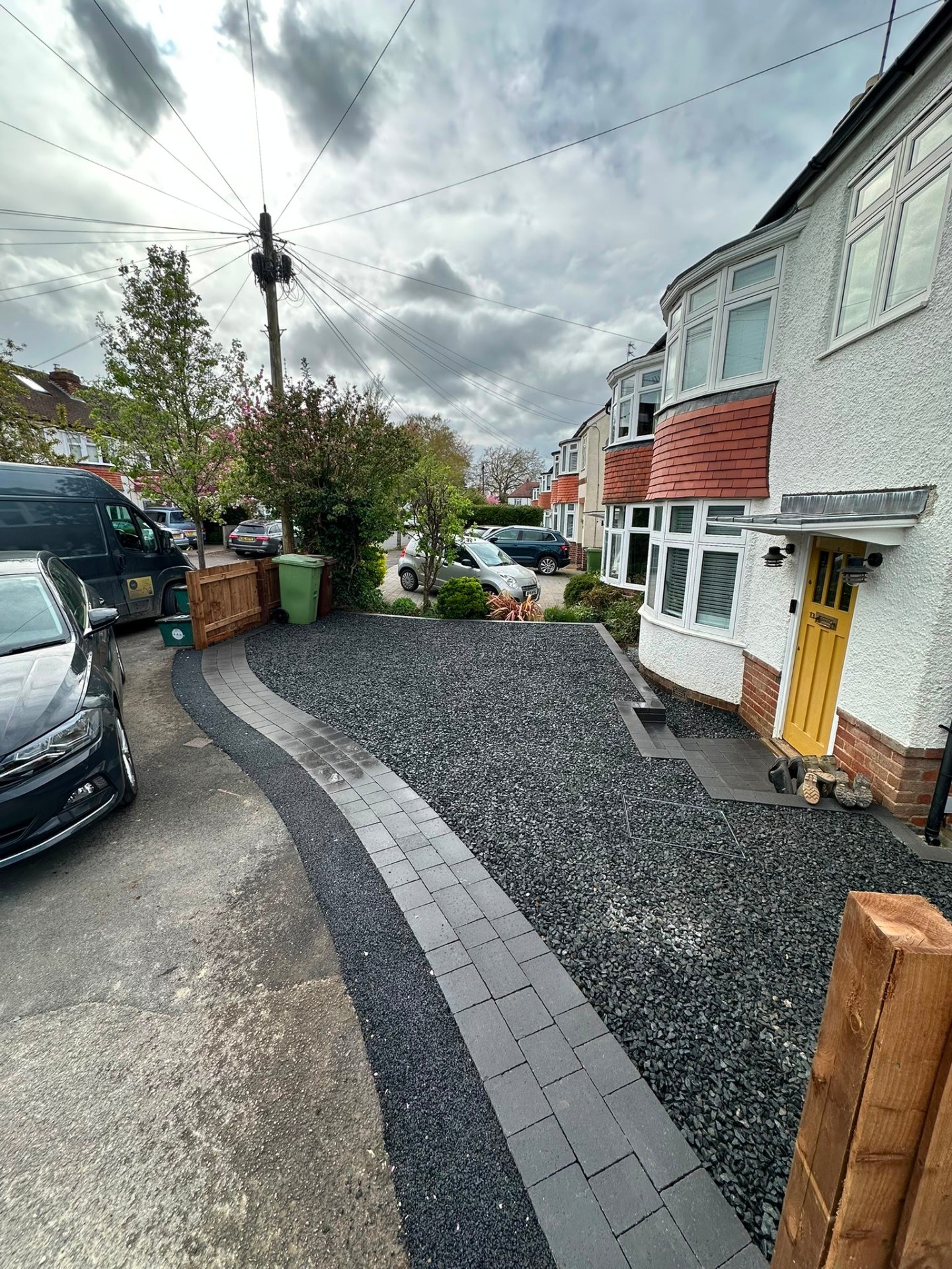 Modern front driveway with dark grey slate chippings and block pave border edging.